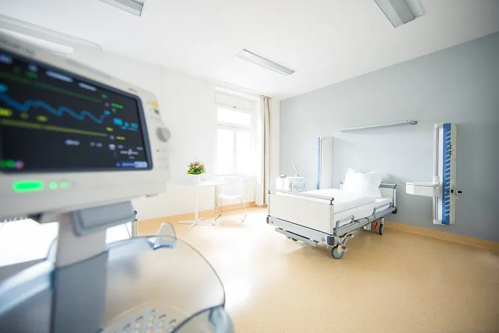 Patientenzimmer mit Bett und Überwachungsmonitor