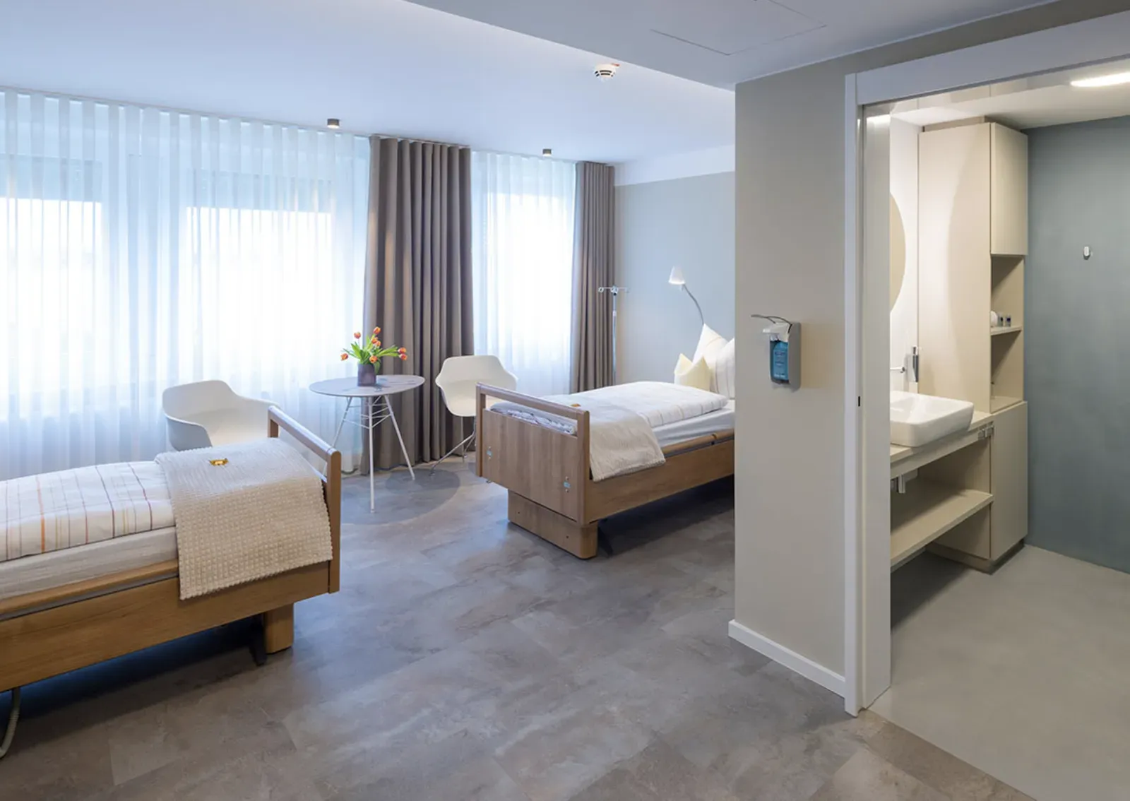 Patientenzimmer mit zwei Betten und eigenem Bad