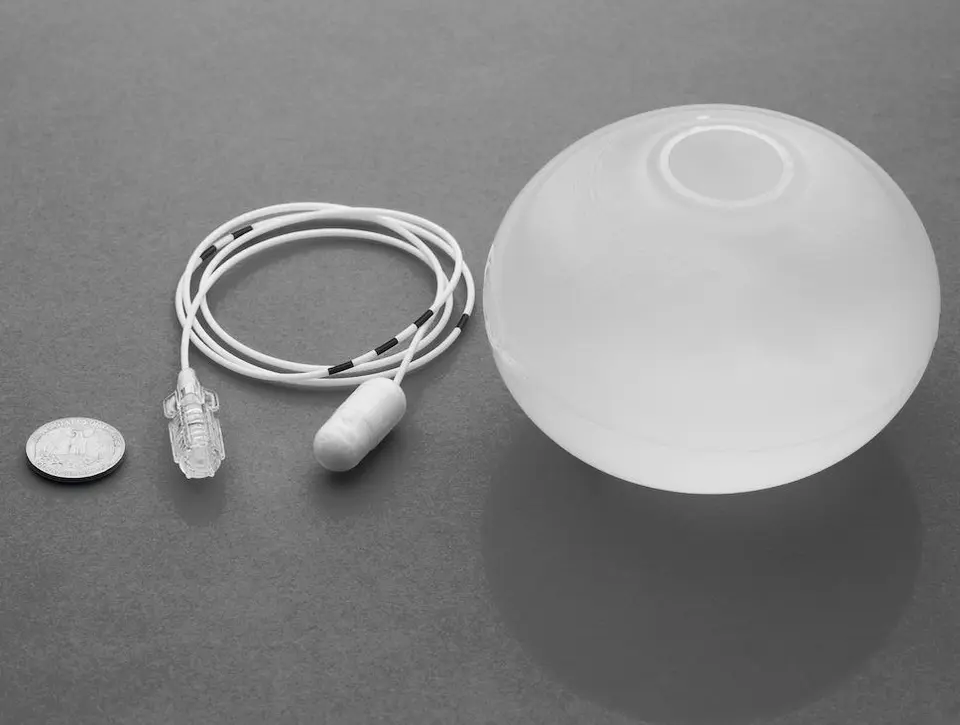 De Allurion-maagballon: links een munt ter vergelijking van de grootte, ernaast de capsule met de dunne vulslang, rechts de gevulde ballon