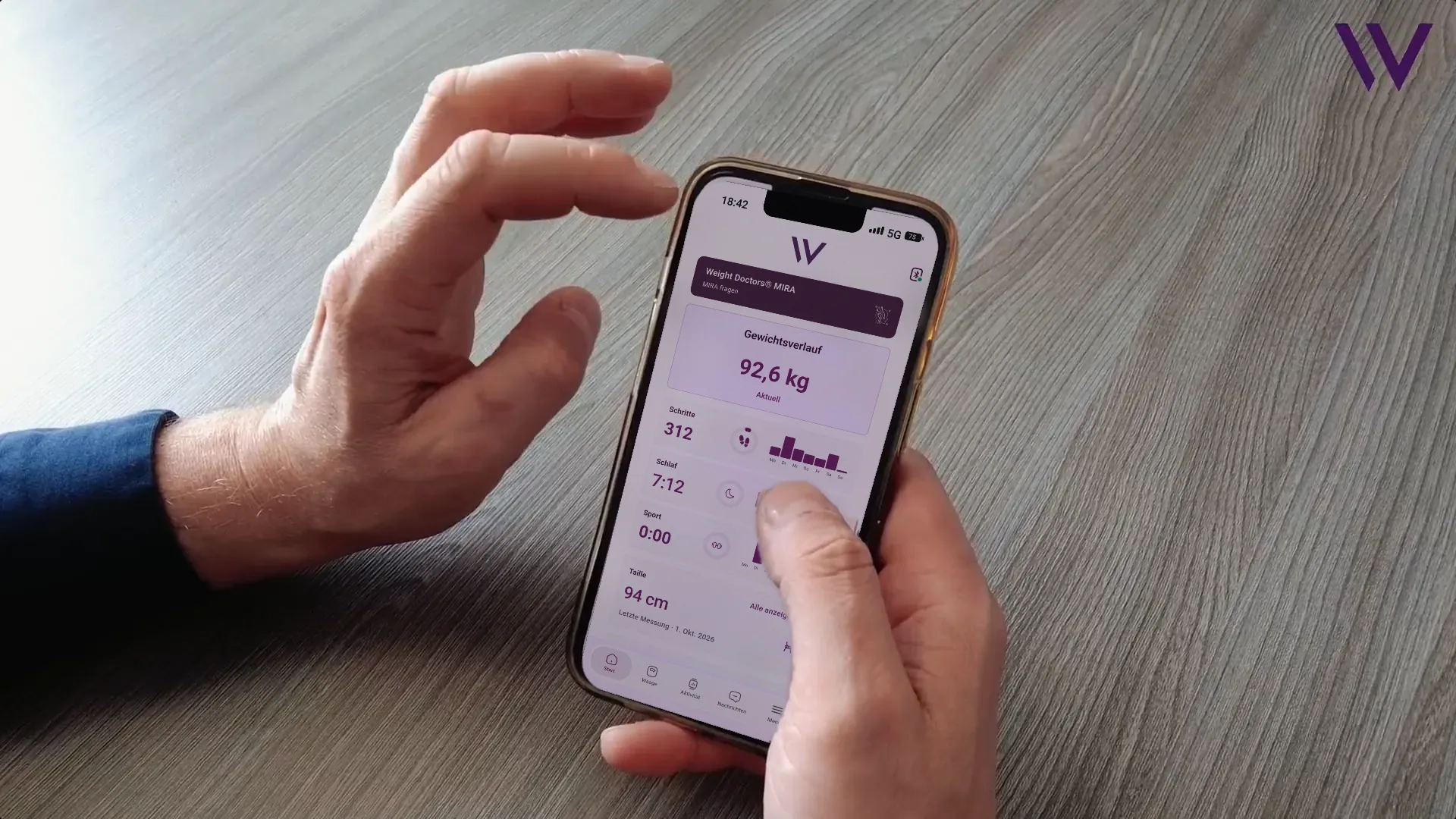 Hand houdt een smartphone vast met de geopende Weight Doctors® App