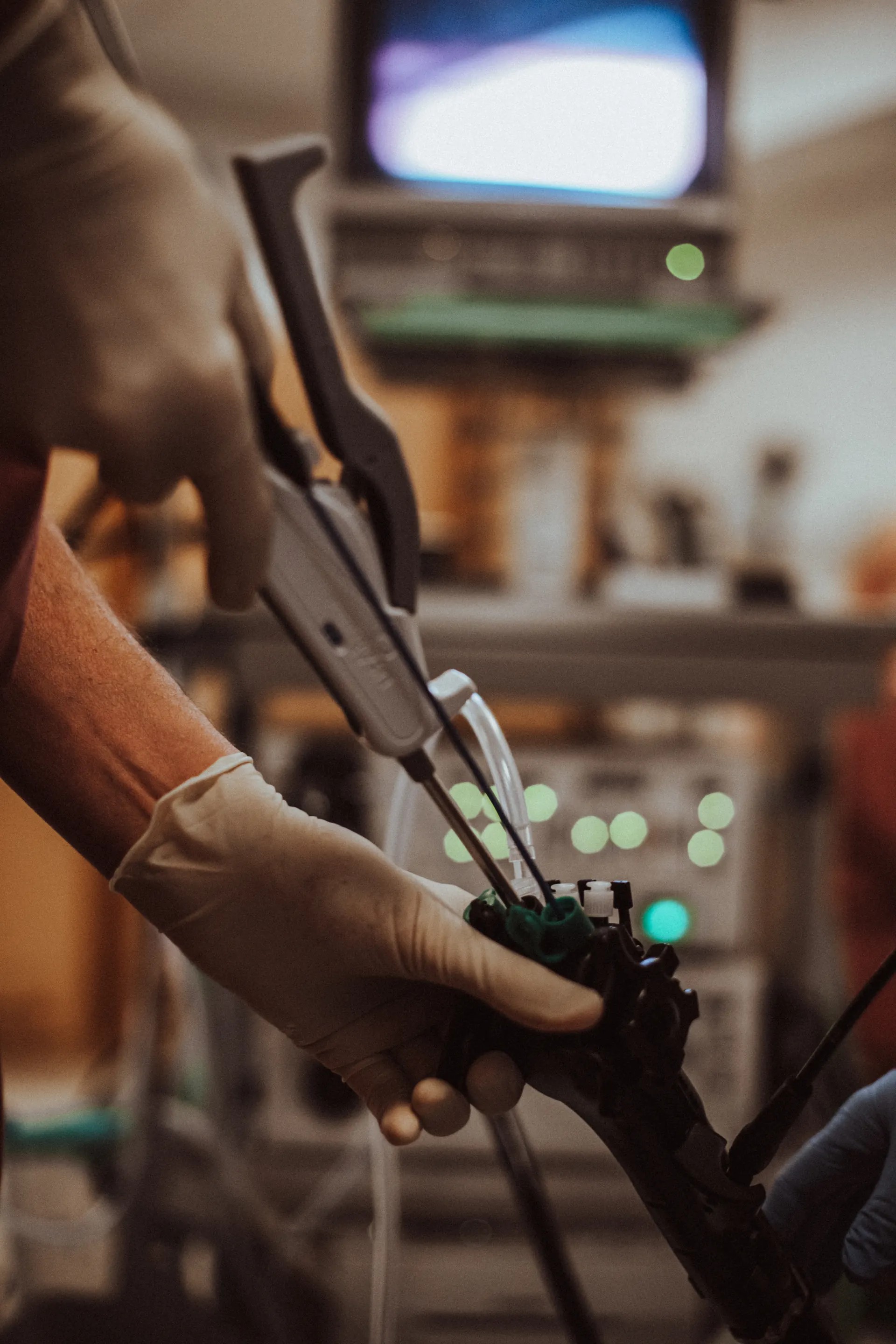 Handen leiden een endoscopisch instrument, op de achtergrond de monitor